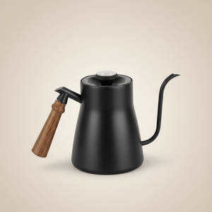 Black kettle with wooden handle on beige background