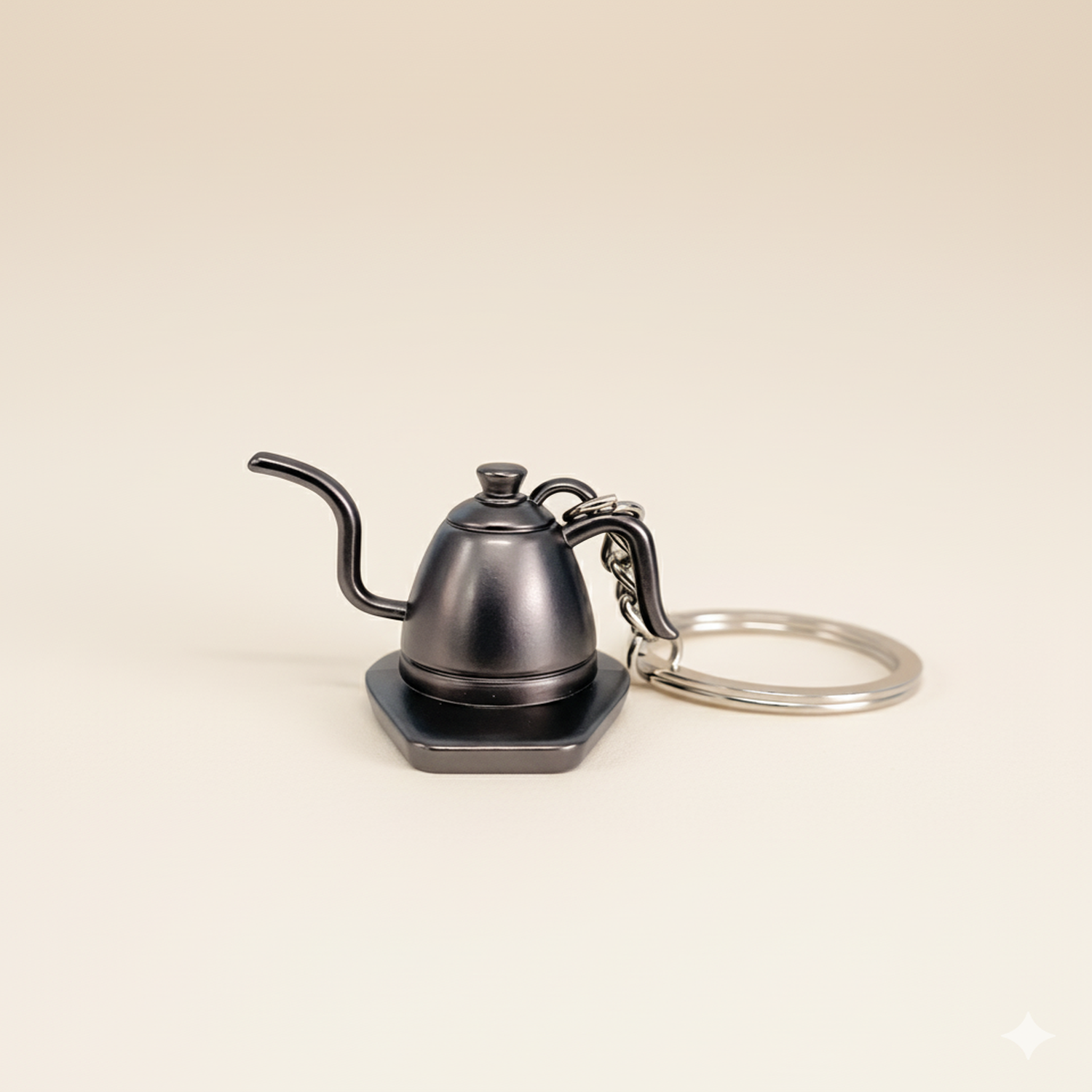Keychain shaped like a coffee kettle on a beige background